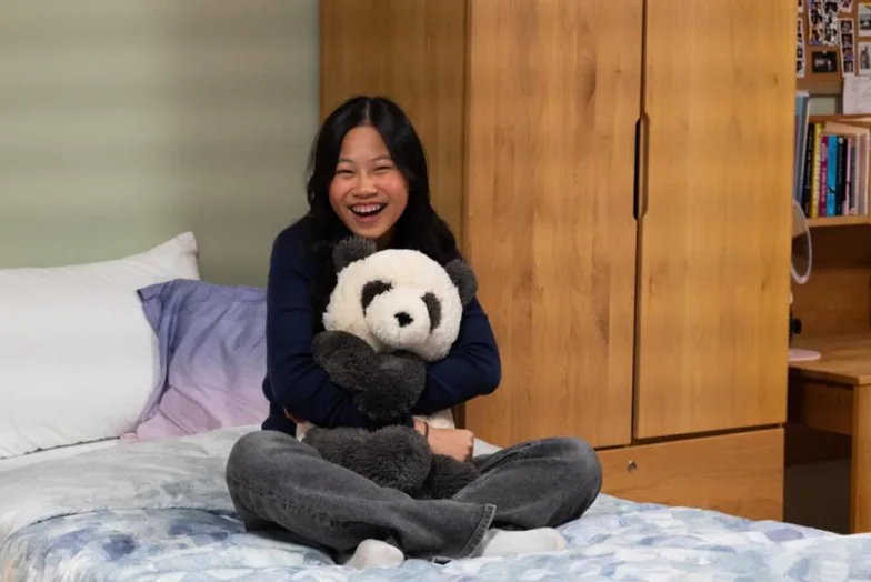 Student relaxing in her boarding room