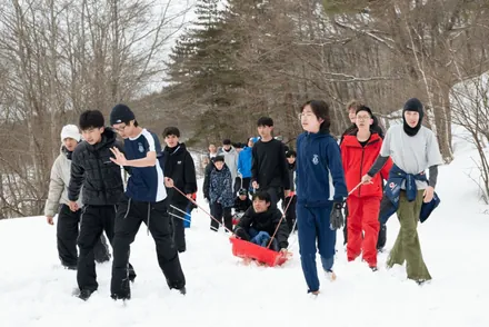 Students hauling a sledge through the snow at Appi Kogen