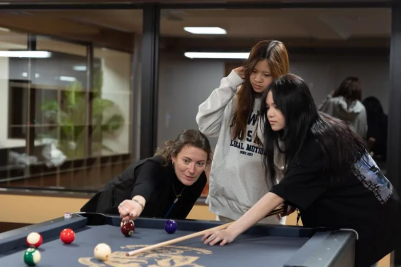 Students playing pool in the boarding house